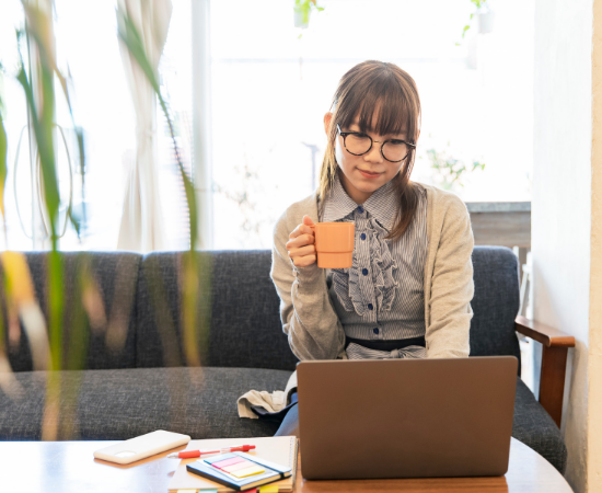 Asian woman holding mug and working