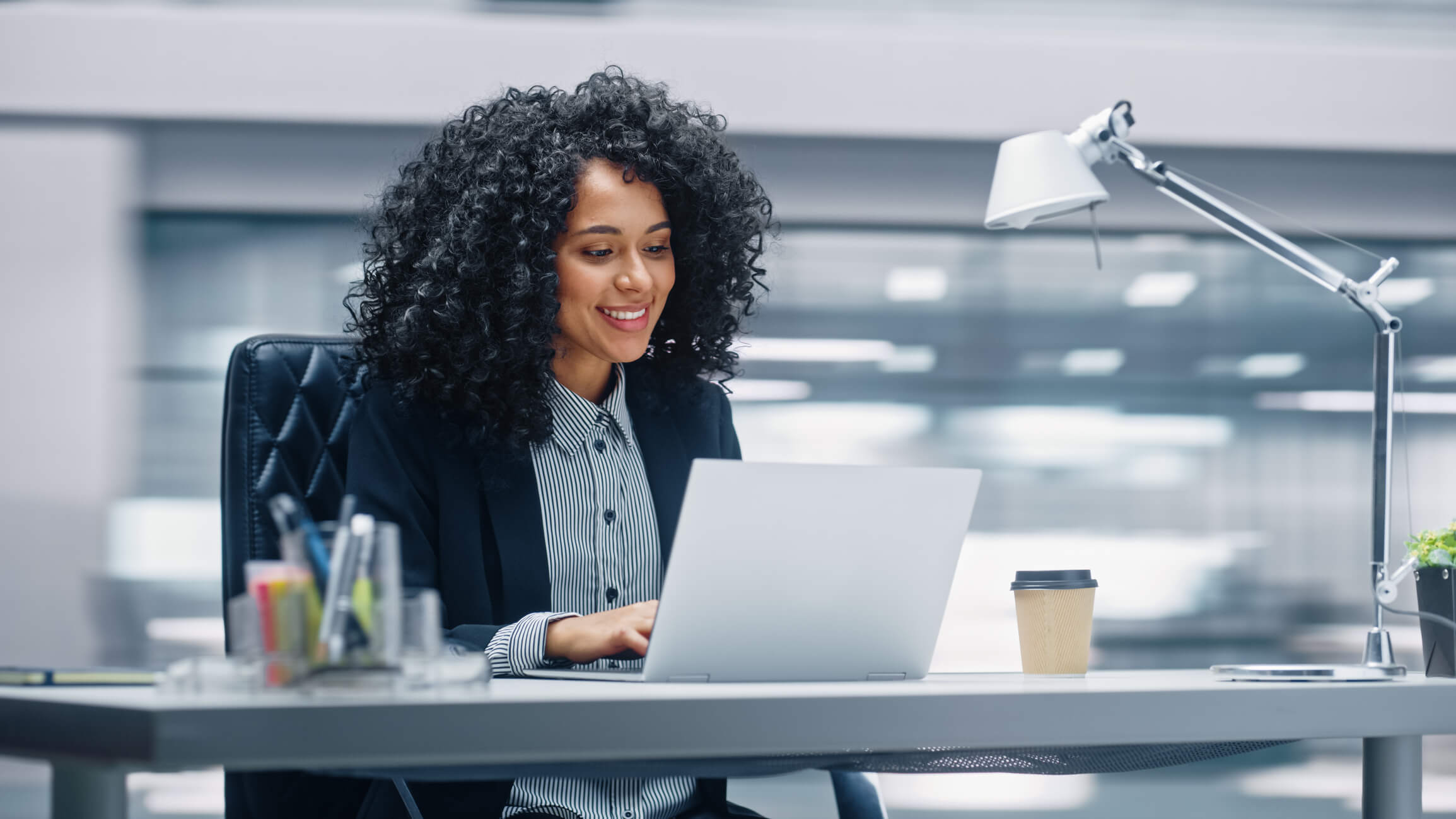 A woman in an office looking at business intelligence for utilities on a laptop.