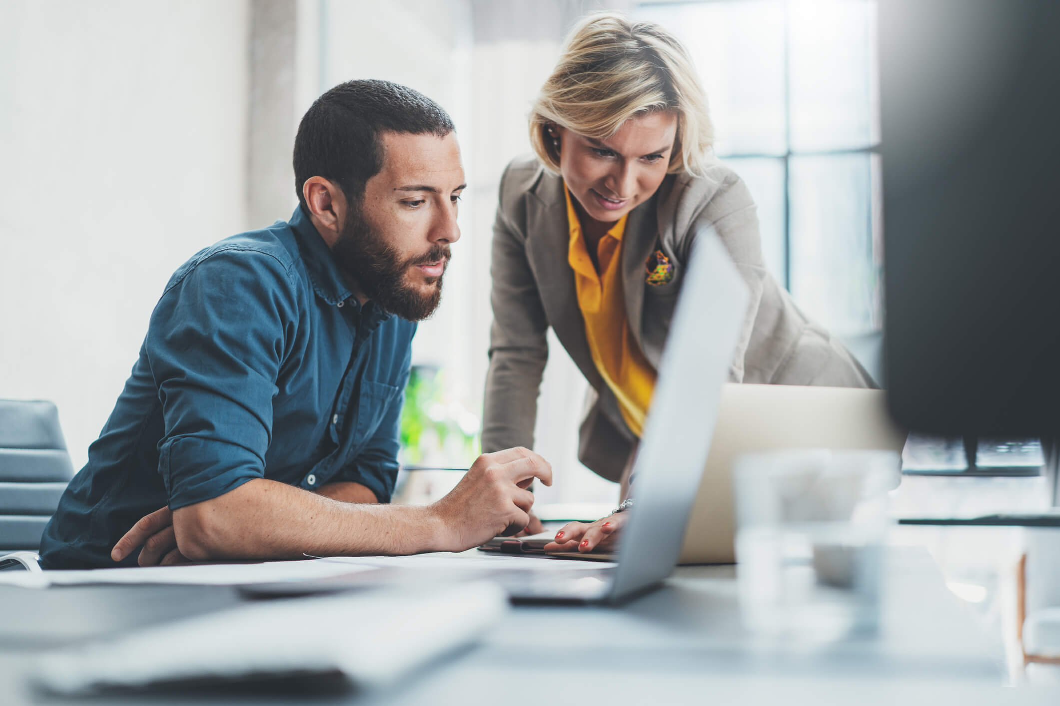 A woman and man looking at AMI data management details on a laptop.